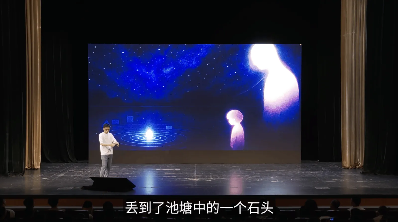 剧场舞台上,大萤幕是星空与两个发光的人形